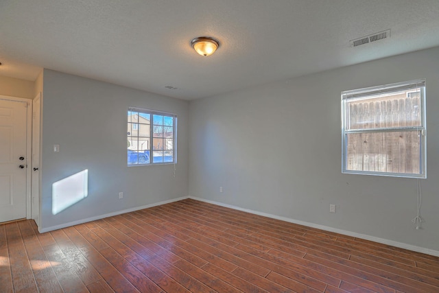 spare room with dark hardwood / wood-style flooring and a textured ceiling