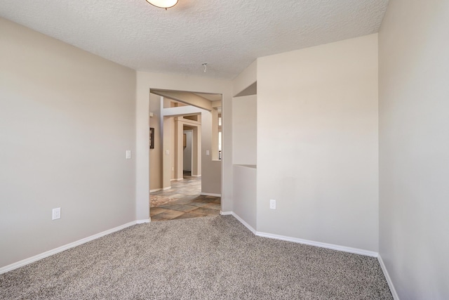 spare room featuring carpet and a textured ceiling