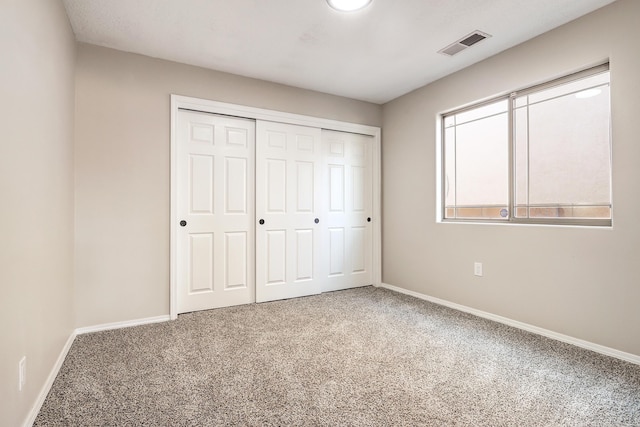 unfurnished bedroom featuring a closet and carpet flooring