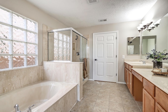 bathroom featuring shower with separate bathtub, tile patterned floors, a textured ceiling, and vanity