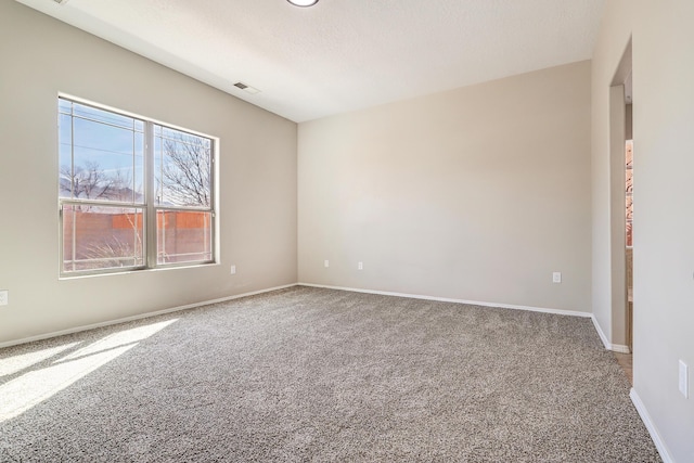 carpeted empty room featuring a textured ceiling