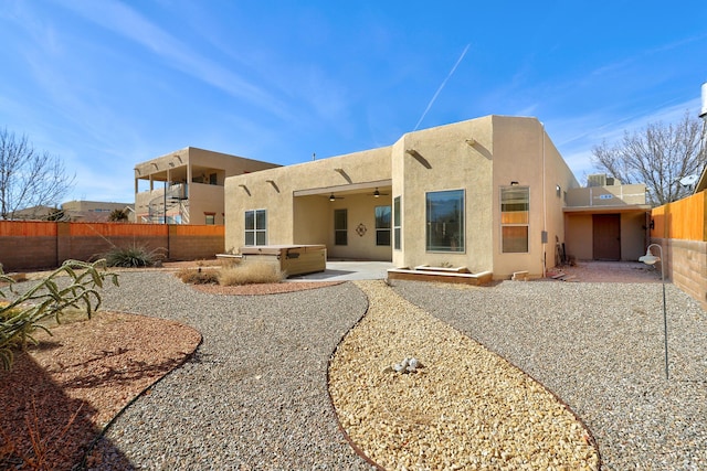 back of house with a hot tub, a patio, and ceiling fan