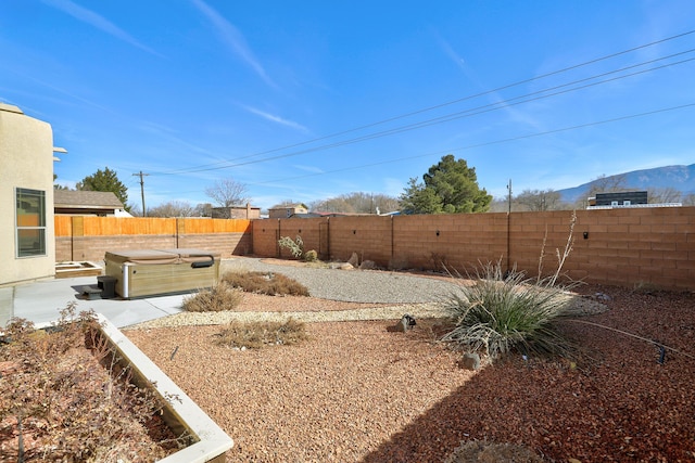 view of yard featuring a hot tub and a mountain view