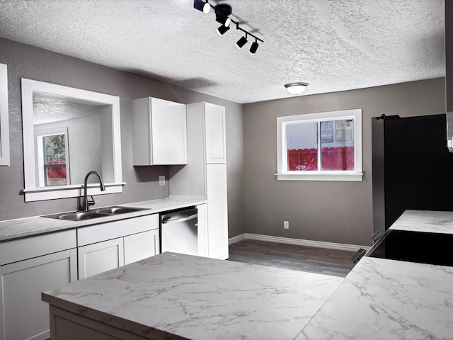 kitchen featuring appliances with stainless steel finishes, light countertops, a sink, and white cabinetry