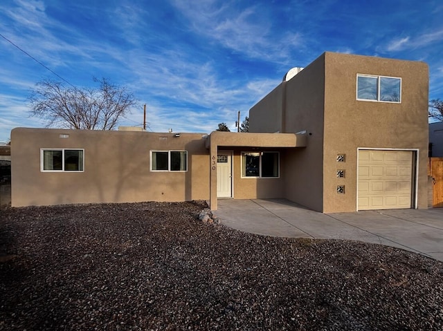 back of property with a patio, an attached garage, and stucco siding