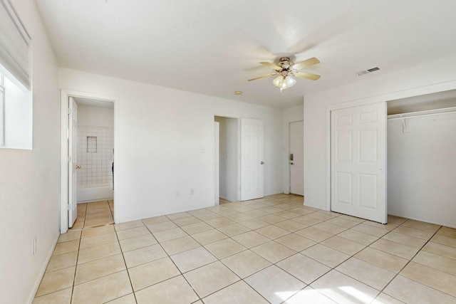 unfurnished bedroom featuring light tile patterned flooring, connected bathroom, ceiling fan, and a closet