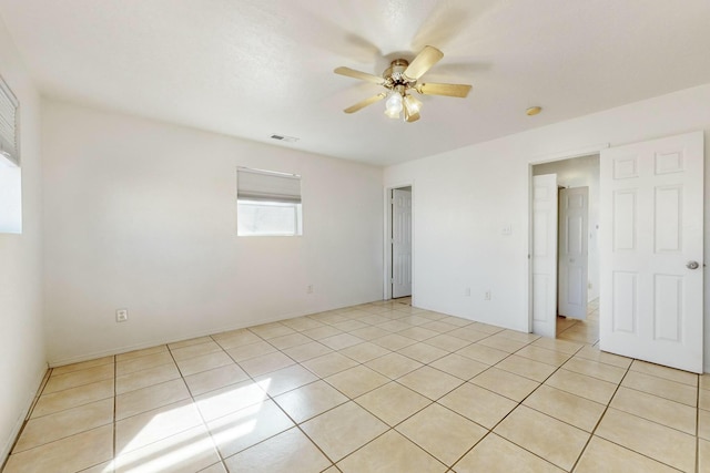 empty room featuring light tile patterned floors and ceiling fan