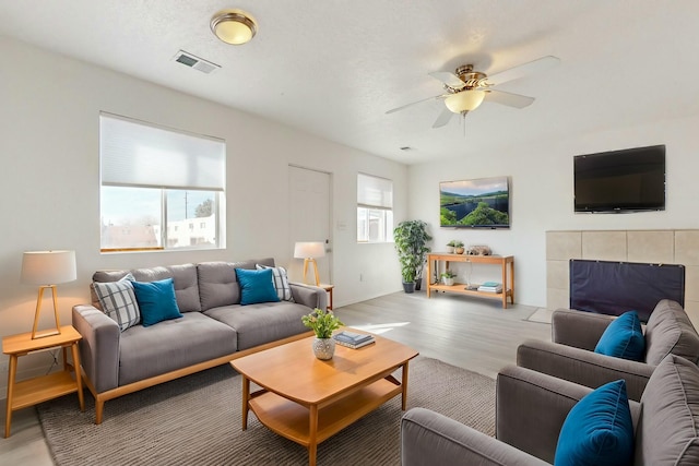 living room with ceiling fan and light wood-type flooring