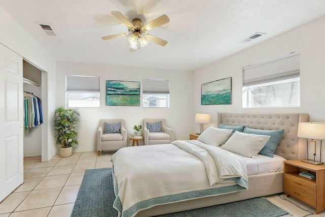 tiled bedroom featuring multiple windows, a closet, and ceiling fan