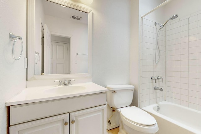 full bathroom featuring tiled shower / bath combo, vanity, and toilet