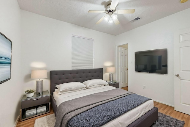 bedroom featuring a textured ceiling, light hardwood / wood-style floors, and ceiling fan