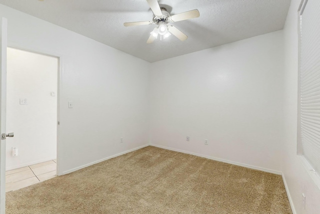 carpeted empty room with ceiling fan and a textured ceiling