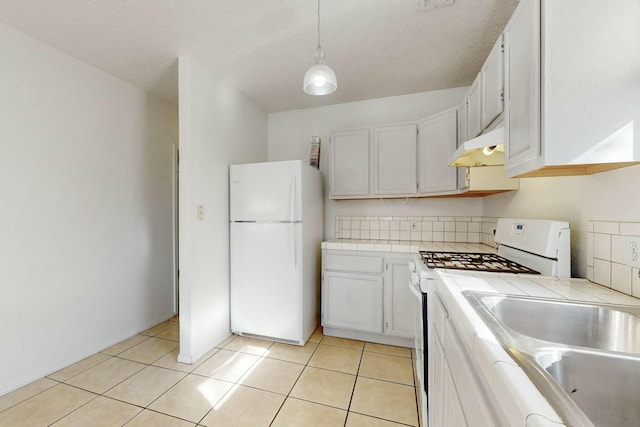 kitchen featuring hanging light fixtures, white cabinets, and white appliances