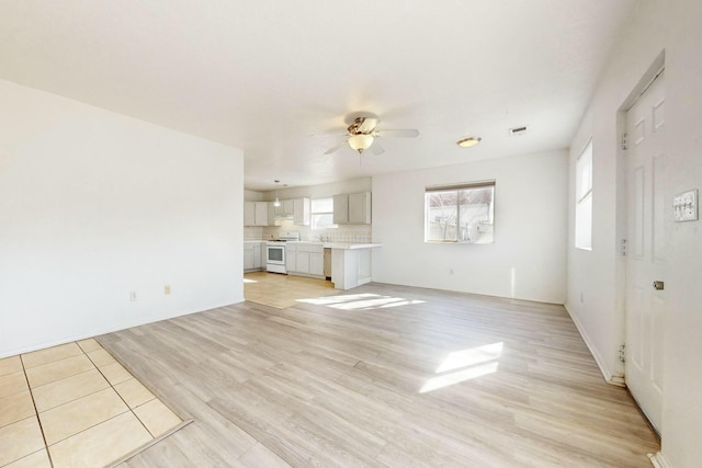 unfurnished living room with ceiling fan and light hardwood / wood-style flooring