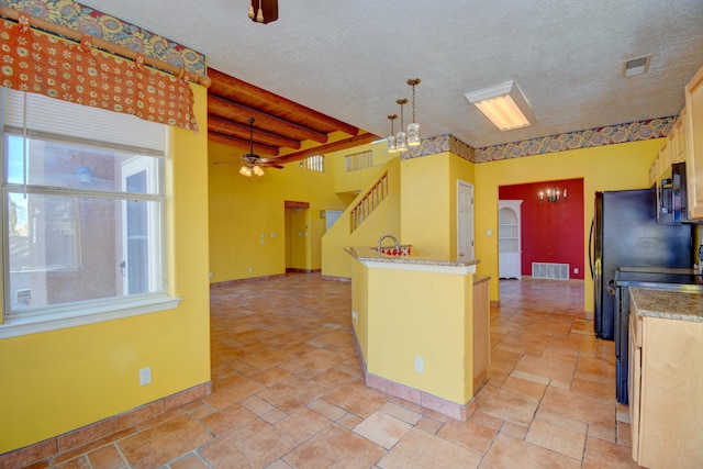 kitchen with ceiling fan with notable chandelier, range, a textured ceiling, and decorative light fixtures