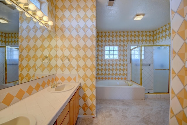 bathroom with tile walls, separate shower and tub, vanity, and a textured ceiling