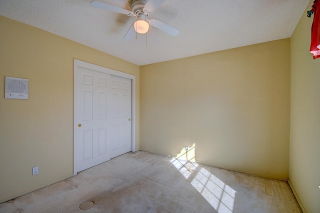 unfurnished bedroom featuring light colored carpet and ceiling fan