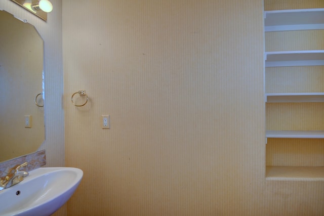 bathroom featuring built in shelves and sink