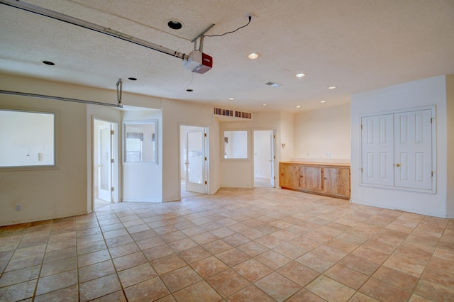 interior space with light tile patterned floors and a textured ceiling