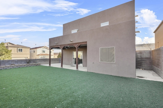 back of house with a patio area and a lawn