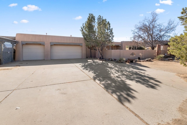 pueblo revival-style home featuring a garage