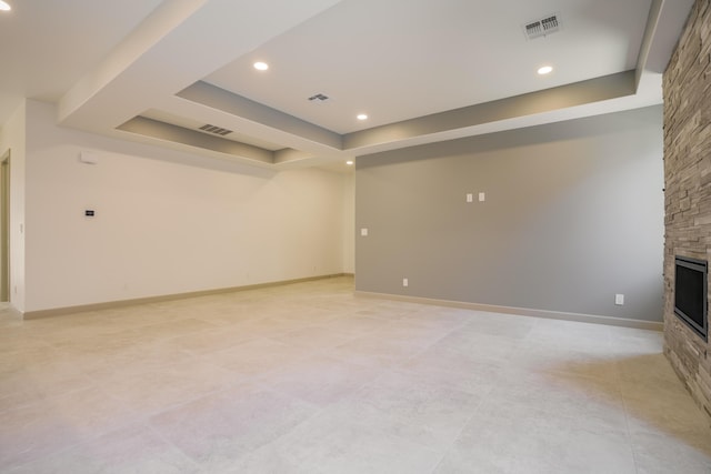 unfurnished living room featuring a fireplace and a raised ceiling