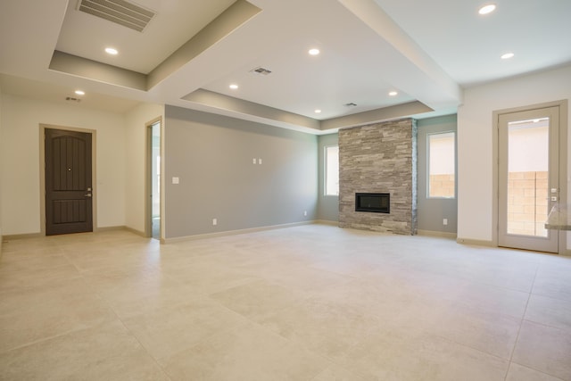 unfurnished living room with a fireplace and a raised ceiling