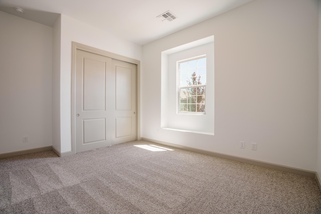 unfurnished bedroom featuring carpet flooring and a closet