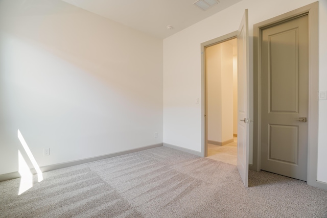 unfurnished room featuring light carpet