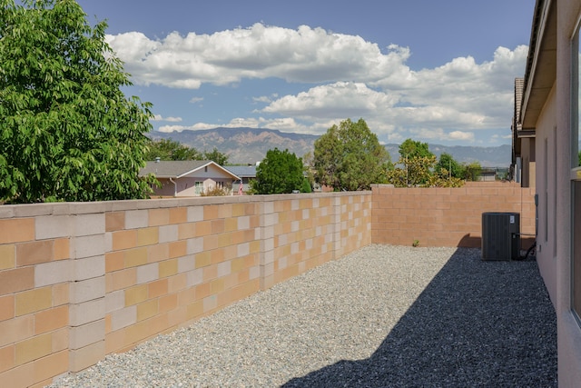 view of yard with a patio, a mountain view, and central AC unit