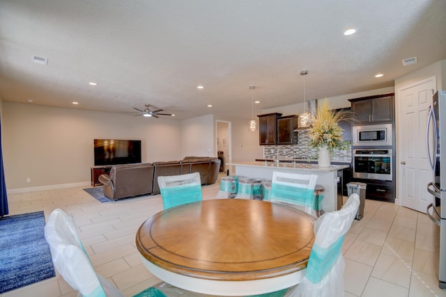 tiled dining room with a textured ceiling and ceiling fan