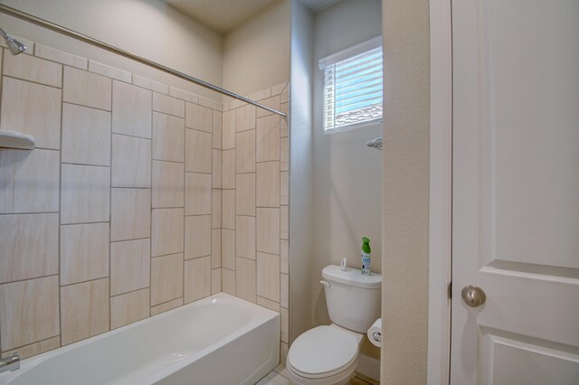 bathroom with tiled shower / bath and toilet