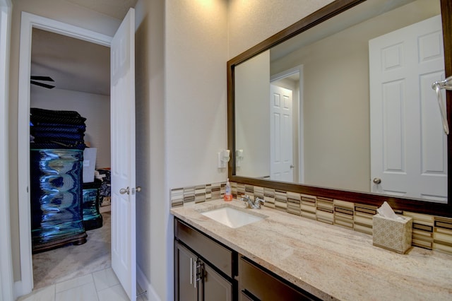 bathroom featuring tile patterned flooring, vanity, and backsplash