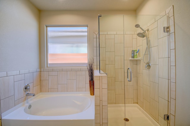 bathroom featuring shower with separate bathtub