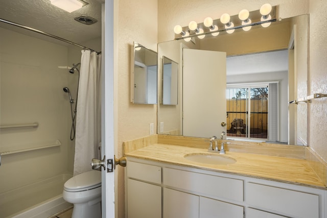 bathroom featuring a shower with curtain, vanity, toilet, and a textured ceiling