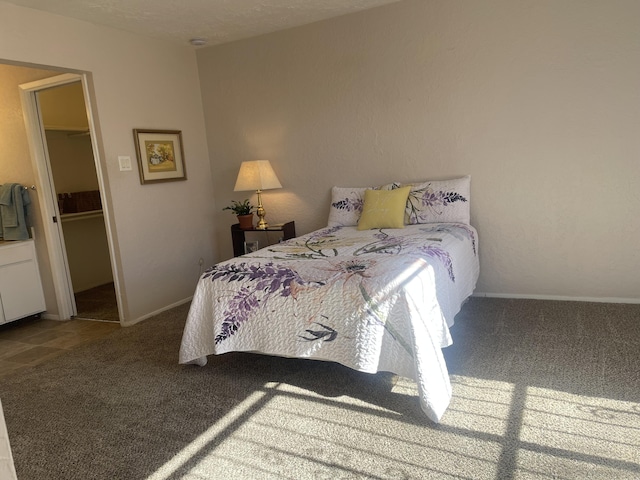 bedroom with carpet floors, a walk in closet, a closet, and a textured ceiling