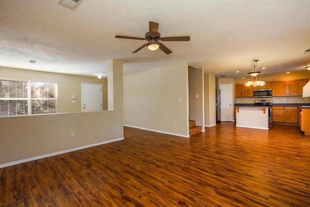 unfurnished living room with ceiling fan, a textured ceiling, and dark hardwood / wood-style flooring