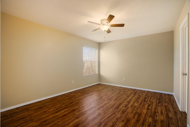 spare room featuring dark wood-type flooring and ceiling fan