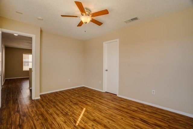 spare room with ceiling fan, dark hardwood / wood-style flooring, and a textured ceiling