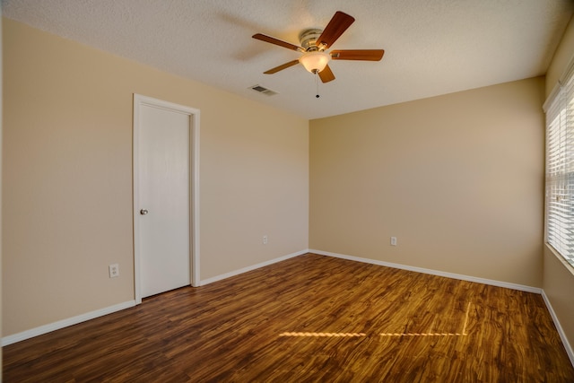 spare room with ceiling fan, dark wood-type flooring, and a textured ceiling