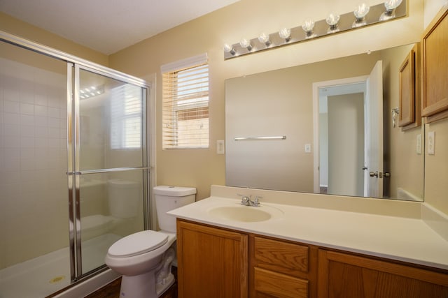 bathroom with vanity, toilet, and an enclosed shower