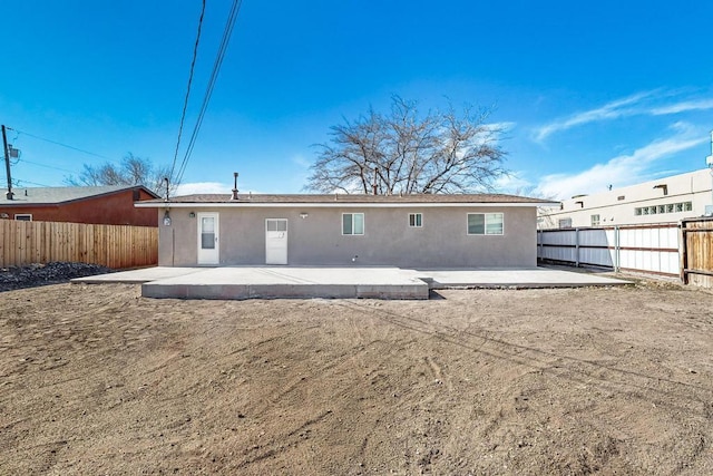 back of house featuring a patio area, a fenced backyard, and stucco siding