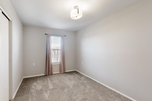 empty room with light colored carpet and baseboards