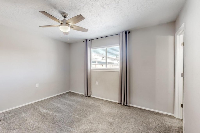 carpeted empty room featuring baseboards and a textured ceiling