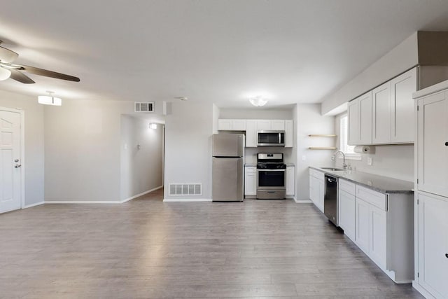 kitchen with stainless steel appliances, a sink, visible vents, and white cabinetry