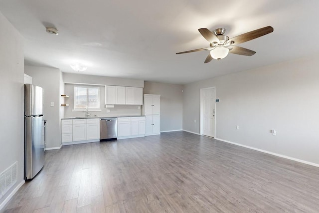 kitchen featuring stainless steel appliances, visible vents, baseboards, light wood-style floors, and white cabinets