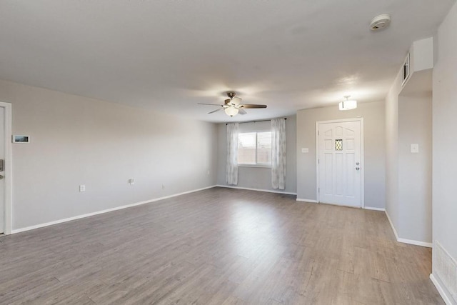 interior space featuring visible vents, ceiling fan, baseboards, and wood finished floors