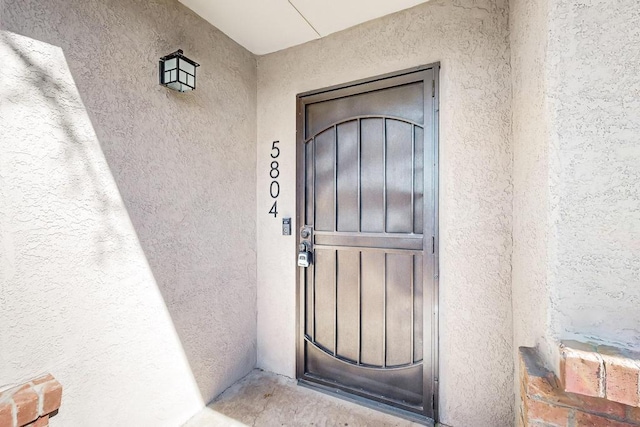 property entrance featuring stucco siding