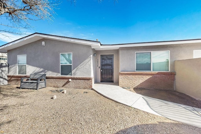 rear view of property with brick siding and stucco siding