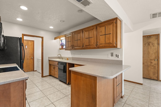 kitchen featuring black appliances, sink, light tile patterned floors, kitchen peninsula, and a textured ceiling